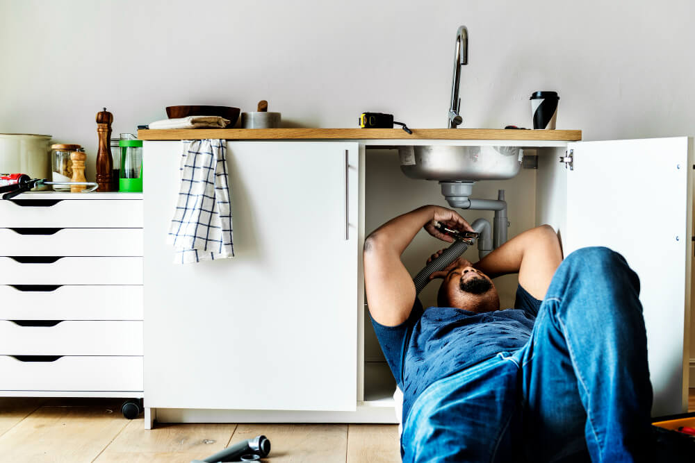Plumber working on pipes in Newcastle home